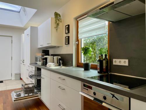 a kitchen with white cabinets and a window at 2-Zi. Apartment 42 qm, an der Friedrichsau/Messe in Neu Ulm