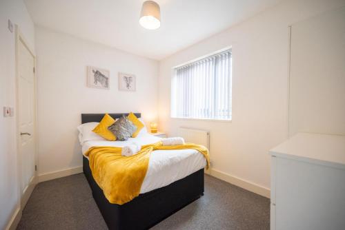 a bedroom with a bed with a yellow blanket on it at Pottery House by YourStays in Stoke on Trent