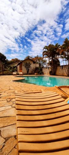 una piscina con escalones de madera frente a una casa en Villa D'Ouro Pousada, en Tiradentes