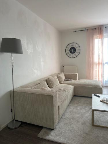- un salon avec un canapé et un réveil sur le mur dans l'établissement Mymi, à Saint-Nazaire