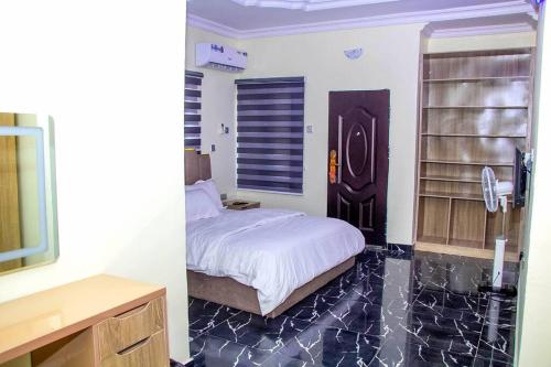 ein Schlafzimmer mit einem Bett und einem TV in einem Zimmer in der Unterkunft Cozy Urban Oasis 3 Bedroom in Ogba, Ikeja, Lagos in Egba
