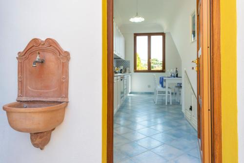uma cozinha com um lavatório de cobre numa parede em CASA OLGA, UN AFFACCIO SUL MARE !! em Praiano