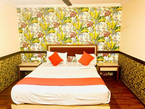 a bedroom with a large bed with orange pillows at The City Park hotel in Hyderabad