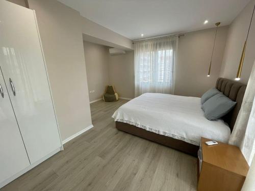 a bedroom with a bed and a dresser in it at Melody Apartment in Korçë in Korçë