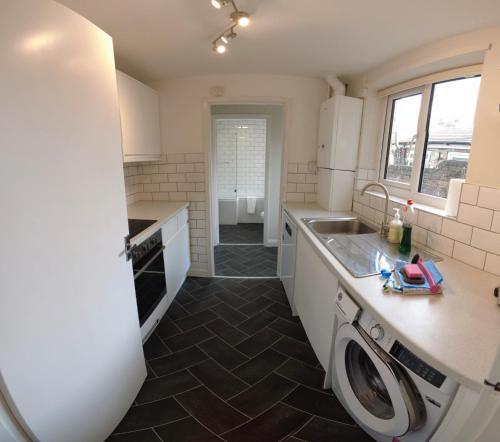 a kitchen with a sink and a dishwasher at 2-bed terraced home - 5 min walk to the City Walls in York
