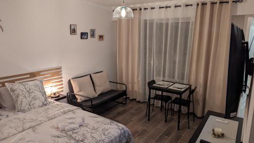 a bedroom with a bed and a chair and a table at Escapade Mulhousienne in Mulhouse
