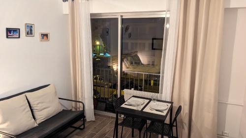 a living room with a couch and a table and a window at Escapade Mulhousienne in Mulhouse