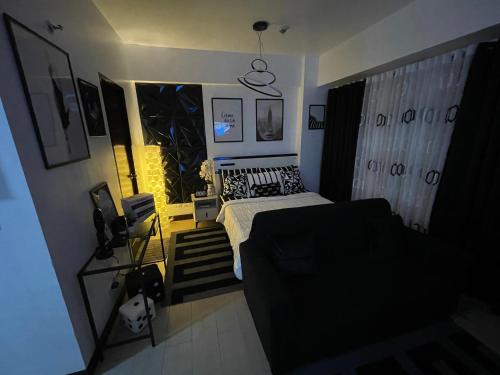 een kleine slaapkamer met een bed en een bank bij Two Palm Tree Villas in Manilla