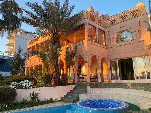 a large house with a palm tree in front of it at Maroccana in Dobra Voda