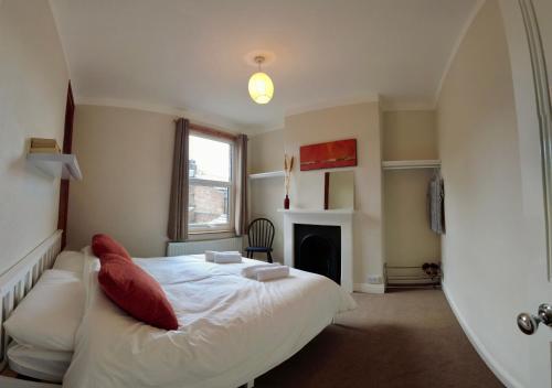 a bedroom with a white bed and a fireplace at 2-bed terraced home - 5 min walk to the City Walls in York
