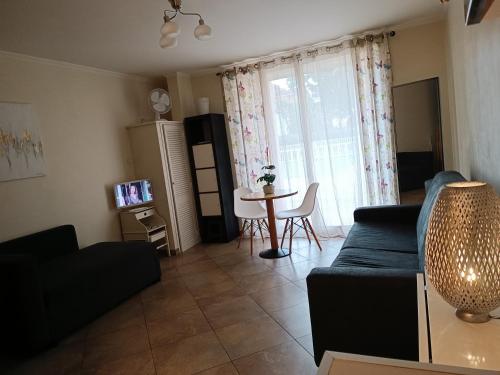 ein Wohnzimmer mit einem Sofa und einem Tisch in der Unterkunft Frontière direct Monaco Studio en Résidence in Beausoleil