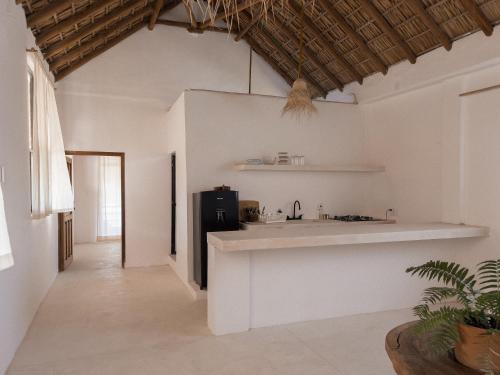 a kitchen with white walls and a black refrigerator at La Punta Rooms in Brisas de Zicatela