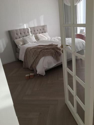 um quarto com uma cama e piso em madeira em Stan- och strandnära poolvilla. em Halmstad