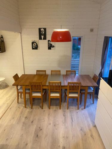 a dining room with a wooden table and chairs at Stuga på ö / närhet till vatten in Mariestad