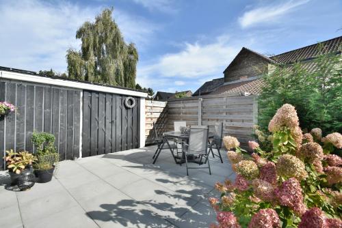 a patio with a table and chairs and a fence at Stylish Home near Maastricht Alicias house in Lanaken