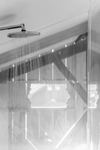a shower with a hose hanging from a ceiling at Bauernchalet elbacher gütel - Exklusives Ferienhaus am Starnberger See in Eurasburg