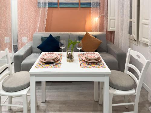 a white table with two chairs and a couch at Flamingo Mini monolocale in Cagliari