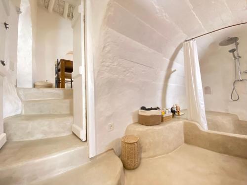 La salle de bains blanche est pourvue d'un escalier, d'une baignoire et d'une douche. dans l'établissement Renovated house in the historic center, à Mojácar