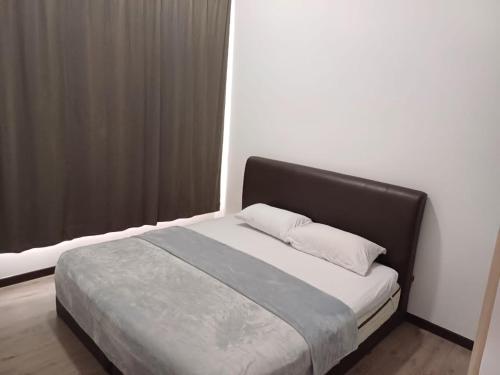 Schlafzimmer mit einem Bett mit einem schwarzen Kopfteil in der Unterkunft Sann's Lodge in Putrajaya