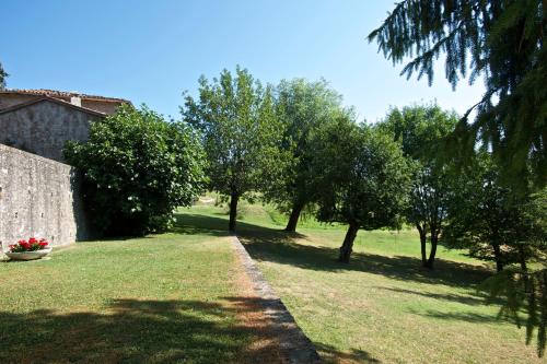 a garden with trees and a building and a wall at B&B CorteBonomini entire home in Sasso