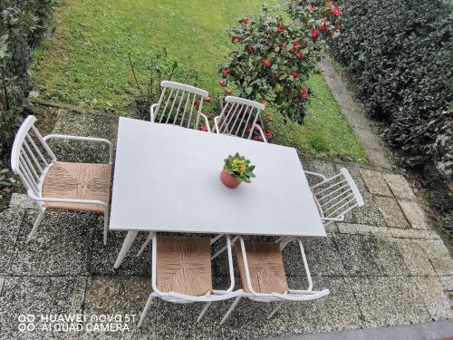 Villetta Camelia في Guamo: طاولة بيضاء وكراسي عليها خزاف