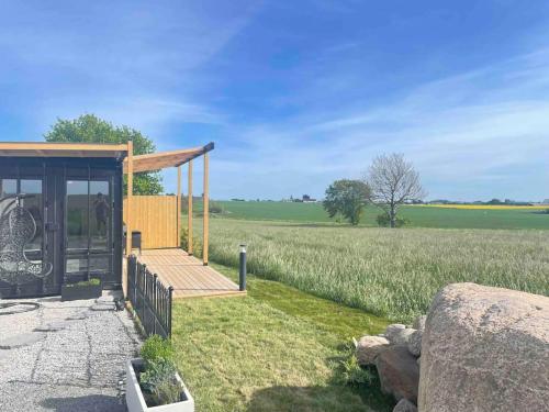 a building with a porch and a field of grass at Container in Hammenhög