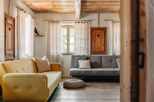 a living room with a couch and a chair at Bauernchalet elbacher gütel - Exklusives Ferienhaus am Starnberger See in Eurasburg