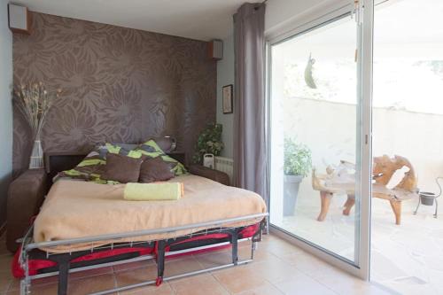 une chambre avec un lit et une porte coulissante en verre dans l'établissement Studio plage, parking gratuit et terrasse privée., à Saint-Mandrier-sur-Mer