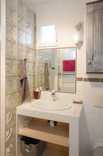 une salle de bain blanche avec un lavabo et un miroir dans l'établissement Studio plage, parking gratuit et terrasse privée., à Saint-Mandrier-sur-Mer