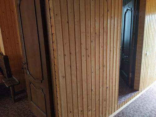 a wooden wall with a door in a room at Family House in Makarovka