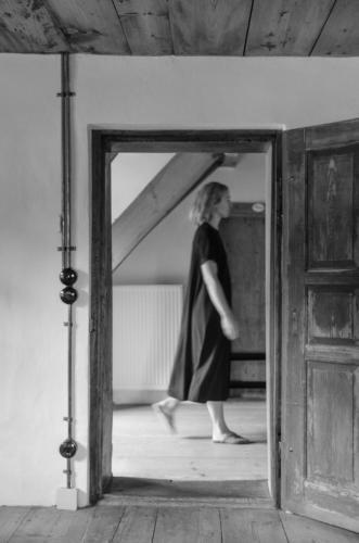 a woman is walking through a mirror in a room at Bauernchalet elbacher gütel - Exklusives Ferienhaus am Starnberger See in Eurasburg