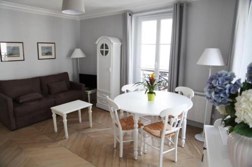 un salon avec une table et un canapé dans l'établissement The Charming Ramey, à Paris