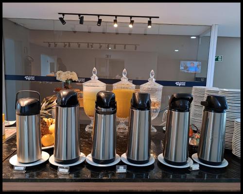 a group of coffee makers on a counter with drinks at Trip Hotel Ubá in Ubá