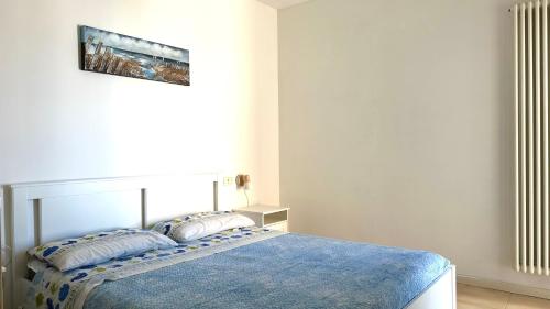 a bedroom with a bed with a blue blanket at SE063 - Marzocca, delizioso bilocale comodo al mare in Marzocca di Senigallia