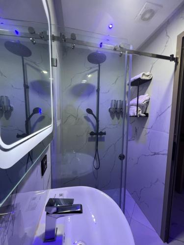 un bagno con doccia e lavandino bianco di Appartement Wow ad Al-Ḥoseyma