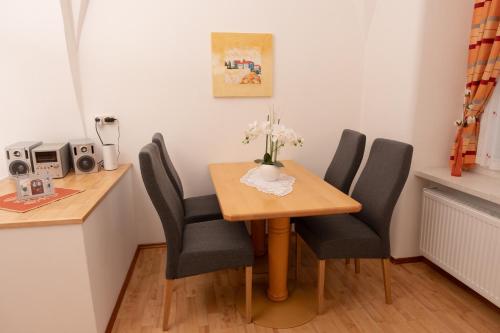 a dining room table with chairs and a vase of flowers on it at Bürgerhaus Martinecz in Bad Radkersburg