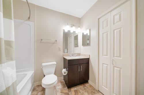 uma casa de banho com um WC, um lavatório e um espelho. em 1B1B Modern Chic in DT Pittsburgh VALET GYM WIFI em Pittsburgh