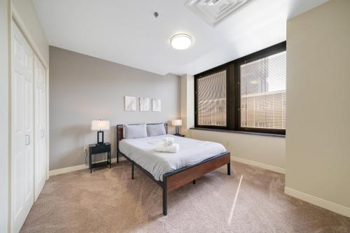 um quarto branco com uma cama e uma janela em 1B1B Modern Chic in DT Pittsburgh VALET GYM WIFI em Pittsburgh