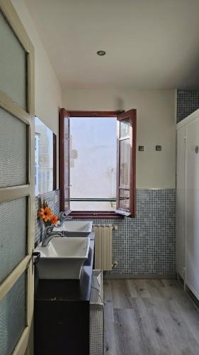 a bathroom with two sinks and a window at Albergue Mayor in Sarria