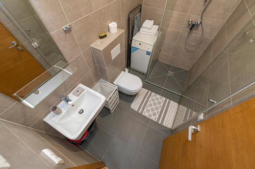 vista sul soffitto di un bagno con lavandino e servizi igienici di UrbanLife Apartment by Polo Apartments a Kaunas