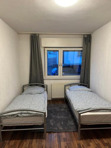 two beds in a room with a window at 2 Zimmer mit 4 Betten (Wohnung Apartment) in Bruchsal