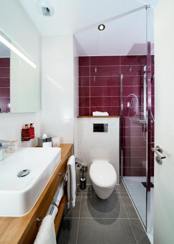 a bathroom with a toilet and a sink and a shower at Hotel Dali Val d'Europe, Tapestry Collection by Hilton in Chanteloup-en-Brie