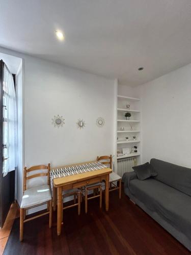 Apartamento en el centro de Llanes في يانس: غرفة معيشة مع طاولة وأريكة
