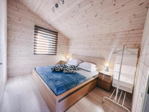 1 dormitorio con 1 cama en una habitación de madera en Ramybės kampelis, en Šventoji