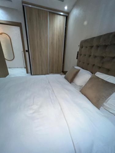 a large white bed in a small room at Appartement Wow in Al Hoceïma