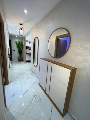 a bathroom with two mirrors and a mirror on the wall at Appartement Wow in Al Hoceïma