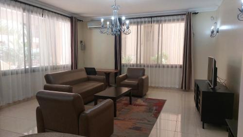 a living room with a couch and chairs and a television at Cozy 3BR w/pool & gym in Dar es Salaam