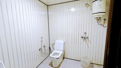 y baño blanco con aseo y ducha. en Triyugi Heights cottage sitapur, en Trijugi Nārāyan