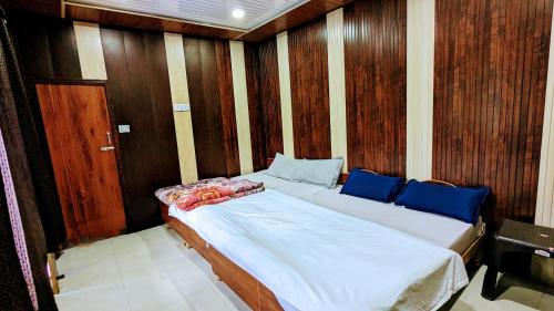 1 dormitorio con 1 cama grande y paredes de madera en Triyugi Heights cottage sitapur, en Trijugi Nārāyan