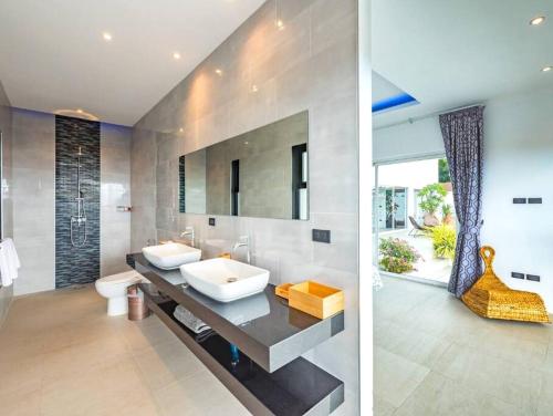 twee afbeeldingen van een badkamer met wastafel en toilet bij 25% OFF! 7 min to Chaweng beach in Nathon Bay